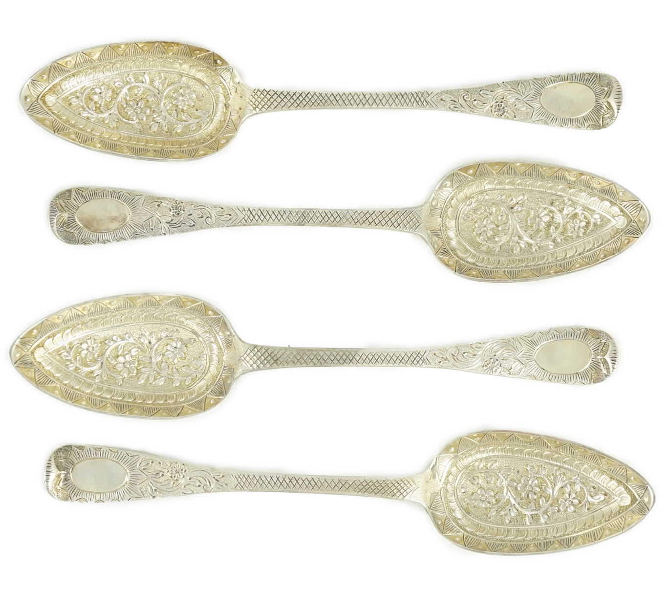 A cased set of four late George III embossed and engraved parcel gilt silver Hanovarian pattern serving spoons, William Chawner II?